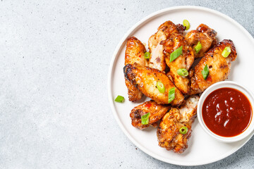 Chicken wings in bbq sauce at white table.