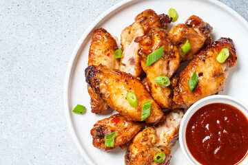 Chicken wings in bbq sauce at white table.