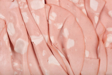 A close-up shot reveals the delicate, overlapping slices of mortadella, showcasing its pale pink...