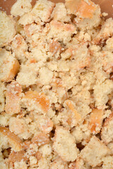 A detailed close-up shows a mixture of irregularly shaped pieces of stale bread, moistened and softened, ideal for preparing bread dumplings or stuffing