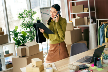 Young entrepreneur working in stylish workspace with boxes and laptop showcasing a modern business...