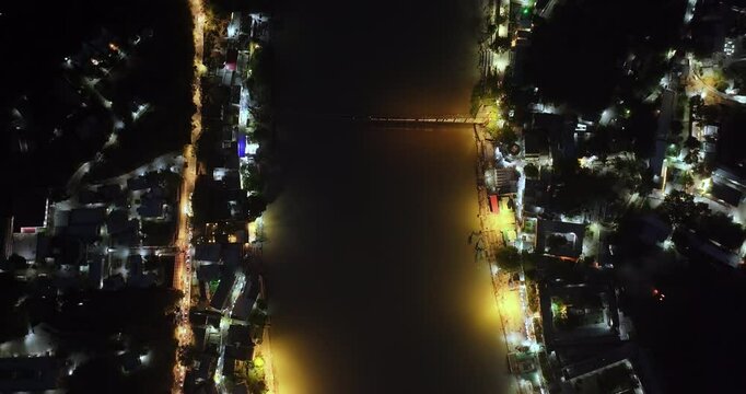 Top Angle Night View of Ganga River at Rishikesh with Half-Lit Lakshman Jhula and Glowing Yellow Riverbank Lights