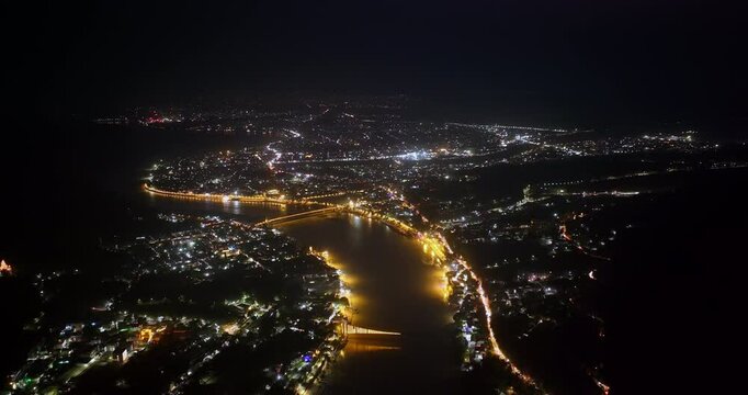 Aerial Night View of Ganga River and Rishikesh City Lights Glowing Along Illuminated Riverbanks