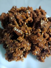 Close-up of crushed organic jaggery mixed with sesame seeds, a natural sweetener used in traditional Indian cooking and healthy desserts. Rich, sticky texture and rustic look.