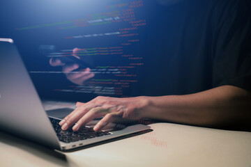 Hands typing on laptop with programming code on screen, representing software development. Perfect...