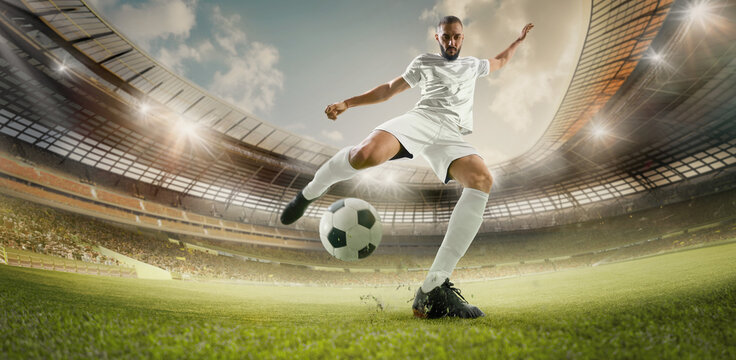 Composite collage. Focused on game young male football player in white uniform, kicking ball, to take free kick on 3D rendering stadium illuminated by spotlights. Concept of sport, championship. Ad