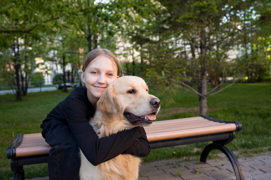 girl with blonde hair hugging her favorite dog golden retriever, child and dog	