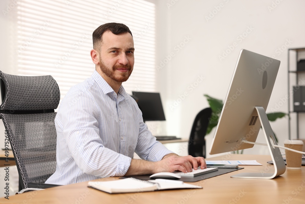 Poster man working on computer at desk in office