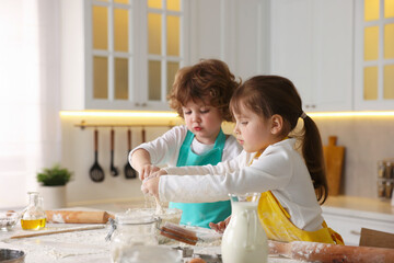 Cooking recipe. Cute children making dough for cookies at table in kitchen