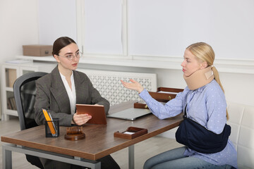 Injured woman having meeting with lawyer in office