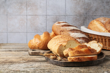 Cut bread loaf and spikes on wooden table. Space for text