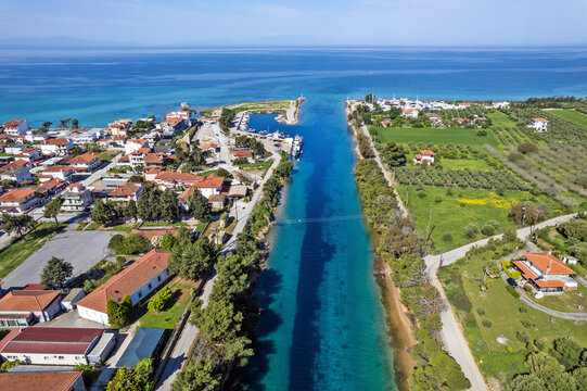 Aerial view of the narrow canal at Nea Potidea in Halkidiki, Greece, connecting the Thermaic and Toroneos Gulfs, with turquoise waters.