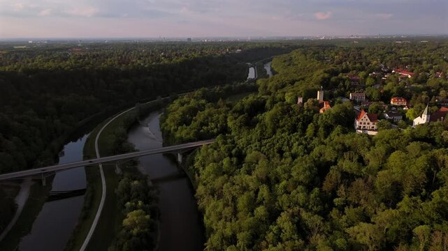 Die Burg Gruenwald thront auf einem Huegel uber der Isar und dem Kanal suedlich von Muenchen. Zu sehen ist die historische Bogenbruecke Gruenwalder Isarbruecke im sommerlichen Bayern, Deutschland. 