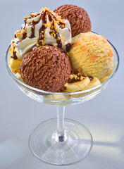 Eiskugeln in Glaschale Schokolade Bananen Eis und Sahnetupfer mit Schokosauce und Bananenstuecken, Eiscreme, 