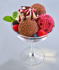 Eiskugeln in Glasschale Schokolade Waldfrucht Eis und Sahnetupfer mit Waldfruchtsauce, Dessert, Eisdessert, Bowl, 