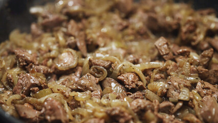 Frying Chicken Liver with Onions in Hot Skillet.