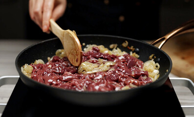 Frying Chicken Liver with Onions in Hot Skillet.