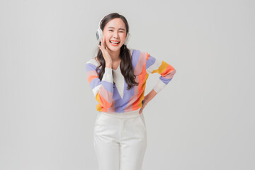 smiling cheerful freshness trendy asian young woman in fashion cloth listening headphone music while dancing hand move gesture happiness enjoy leisure lifestyle moment studio shot portrait 