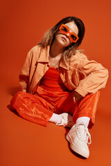A young woman showcases a bold fashion statement with her chic orange ensemble