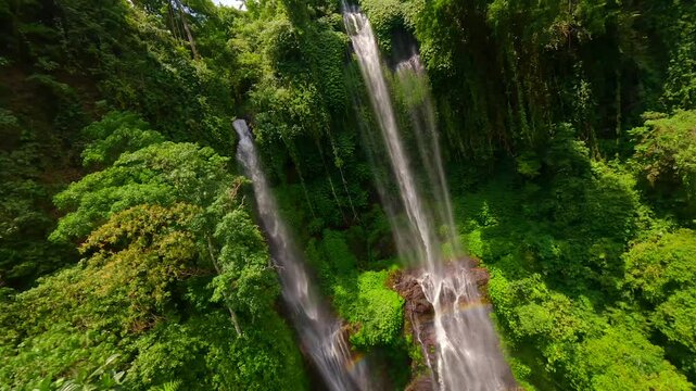 Cinematic FPV drone flight through cascading waters of Sekumpul Waterfall, surrounded by lush green jungle in Bali, Indonesia. Ideal for nature, travel, and tropical adventure themes.