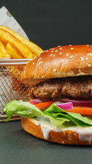 Fresh beef burger with Crispy French fries closeup on black background