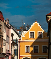 Naklejka premium A view along a historical European street showcases buildings with diverse colors and architectural styles.