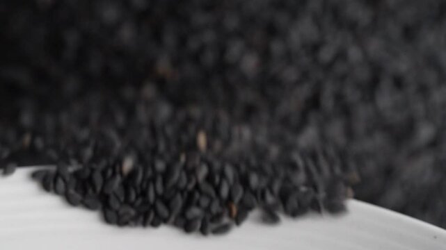 Macro video of black sesame seeds kept on rotating disk. Close up of black sesame seeds.