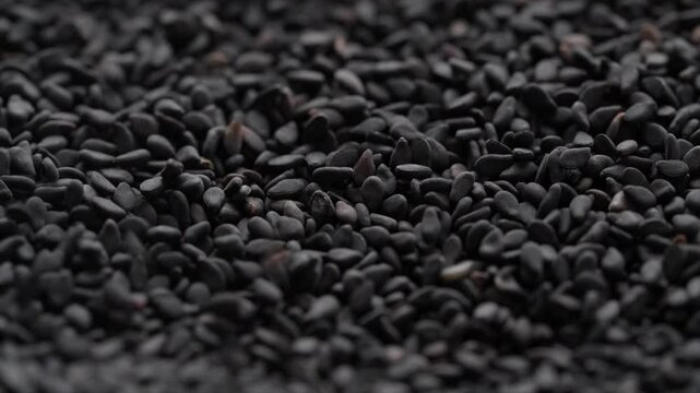 Macro video of black sesame seeds kept on rotating disk. Close up of black sesame seeds.