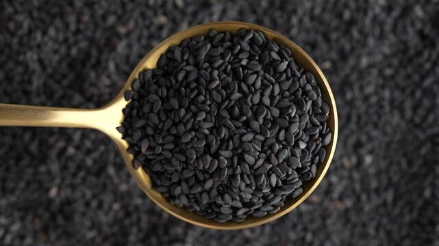 Macro video of black sesame seeds kept on rotating disk. Close up of black sesame seeds.