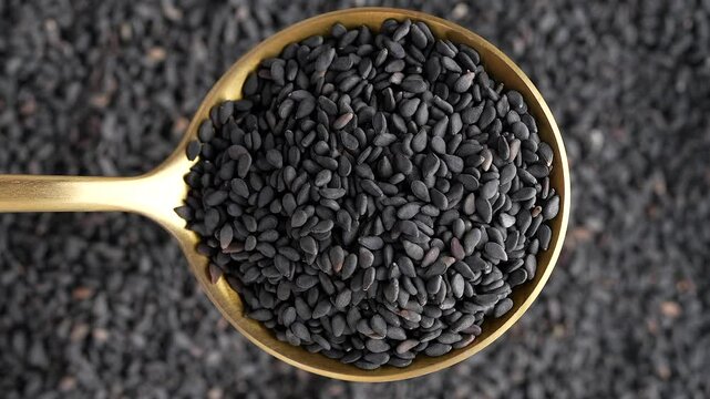 Macro video of black sesame seeds kept on rotating disk. Close up of black sesame seeds.