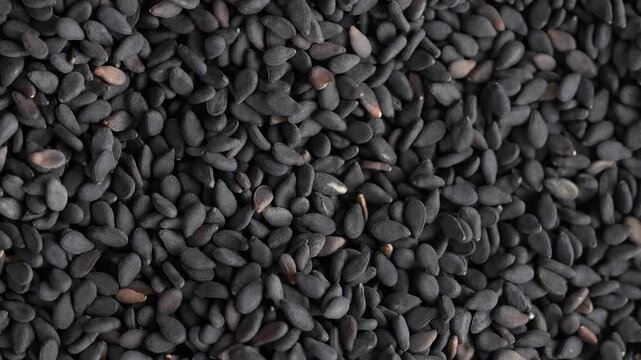 Macro video of black sesame seeds kept on rotating disk. Close up of black sesame seeds.