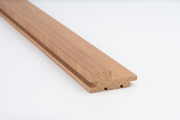 Profiled brown wooden moulding strip with step-shaped contours on white background, ideal for furniture or interior trim. Includes copy space..