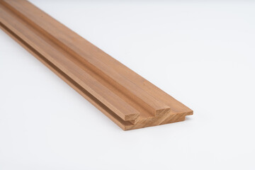 Wooden frame or molding profile with precise grooves, displayed on white background. Cross-section view of construction or furniture component..