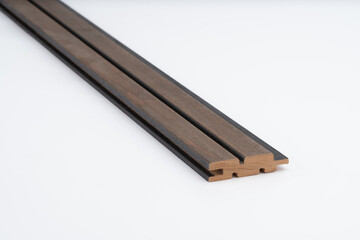 Dark brown wood slat profile with deep black-accented grooves, placed on white background. Suitable for acoustic panels or architectural cladding..