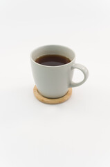 Tazza in ceramica grigia dal design moderno su supporto in legno di bamboo con tisana, sfondo bianco