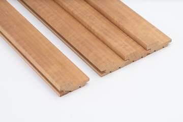 Brown wooden slat panels with rounded edges and tongue-and-groove joints, placed on white background. Ideal for interior cladding or wall decor..