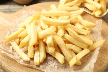Tasty french fries on wooden table, closeup