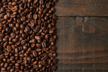 Aromatic coffee beans on wooden table, top view. Space for text