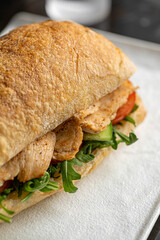 Portion of ciabatta sandwich with chicken and salad
