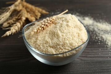 Flour and spike in bowl on dark wooden table, closeup