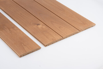 Brown wooden wall slats with subtle grain and deep grooves, arranged neatly on a white background for interior cladding or acoustic use..