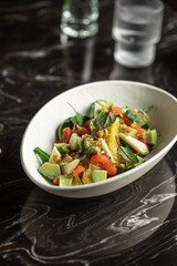 Portion of gourmet salad with avocado and oranges