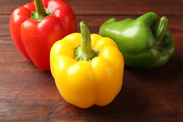 Ripe colorful bell peppers on wooden table, closeup
