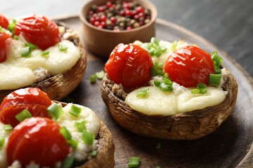 Tasty stuffed mushrooms served on black table, closeup