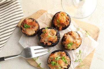 Tasty stuffed mushrooms served on light table, top view