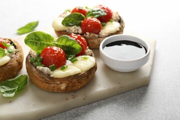 Tasty stuffed mushrooms served on light table, closeup