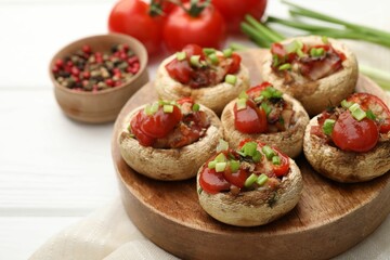 Tasty stuffed mushrooms served on white wooden table, closeup