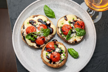 Tasty stuffed mushrooms and drink served on black table, top view