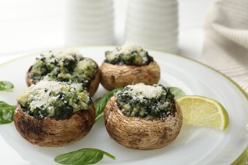 Tasty stuffed mushrooms served on white table, closeup