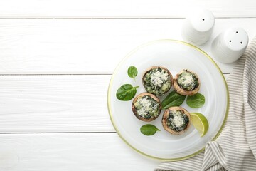 Tasty stuffed mushrooms served on white wooden table, top view. Space for text